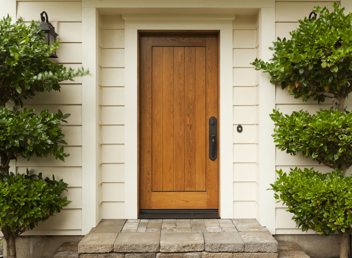 Beautiful wooden front door surrounded by well-maintained shrubs and a neatly paved entryway, enhancing curb appeal and making a great first impression for homebuyers in Oak Ridges.