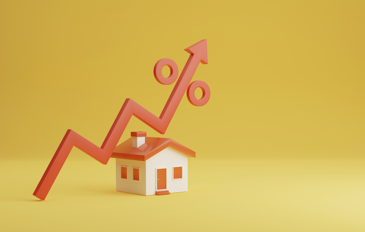 A small red and white house on a yellow background with an upward-trending red arrow and percentage symbol, symbolizing mortgage rate trends, housing affordability, and market conditions in Canada for 2025.